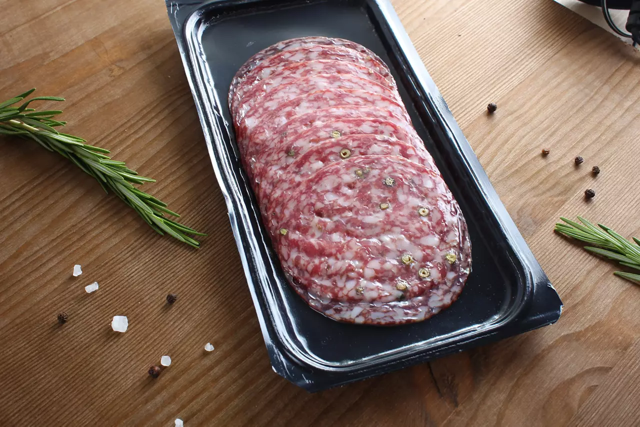 sausage sliced in a package on a wooden background