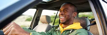 Side portrait of happy person driving car