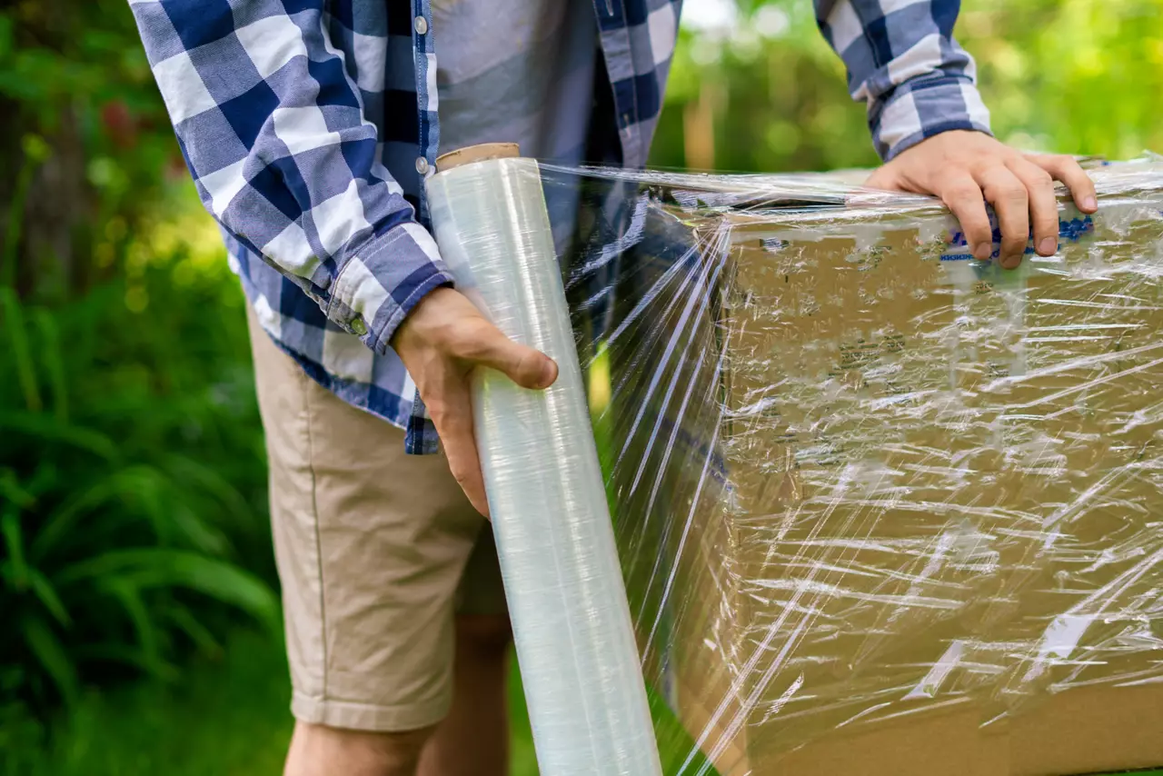 Stretch wrap roll, man packing the box for shipping