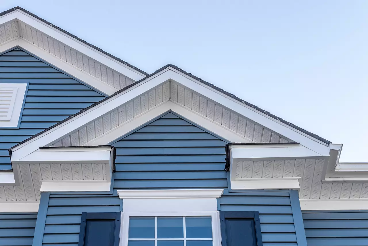 Eves of a blue and white house showing façade, trim and siding